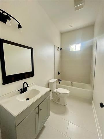 full bathroom with tile patterned flooring, vanity, tiled shower / bath combo, and toilet