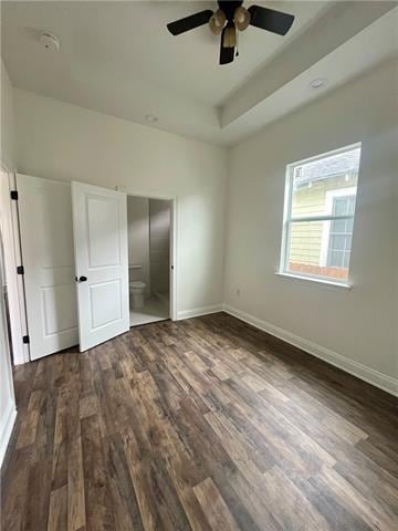 unfurnished bedroom featuring ceiling fan and dark wood-type flooring