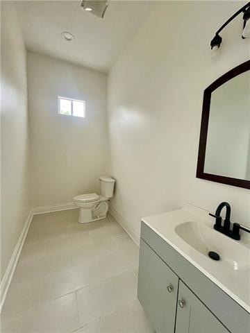 bathroom featuring toilet, vanity, and tile patterned floors