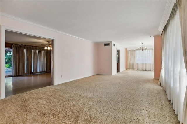 spare room with carpet, ceiling fan with notable chandelier, and ornamental molding