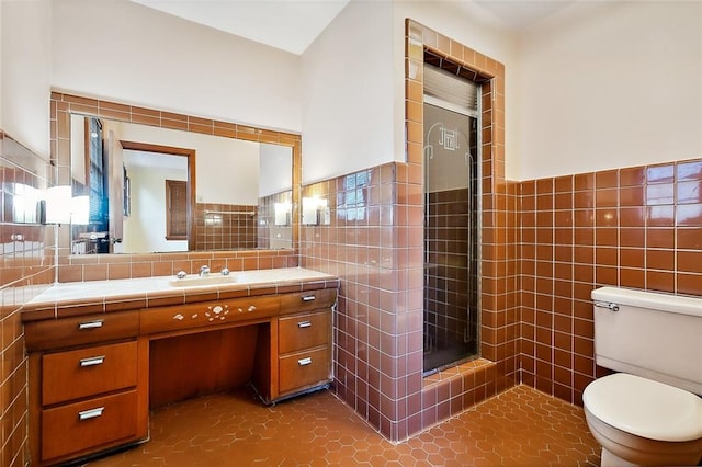 bathroom featuring tile patterned floors, walk in shower, vanity, tile walls, and toilet