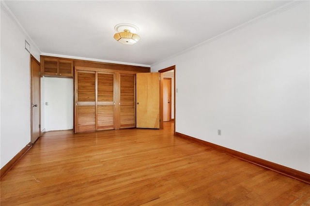 unfurnished bedroom featuring light hardwood / wood-style flooring, a closet, and crown molding