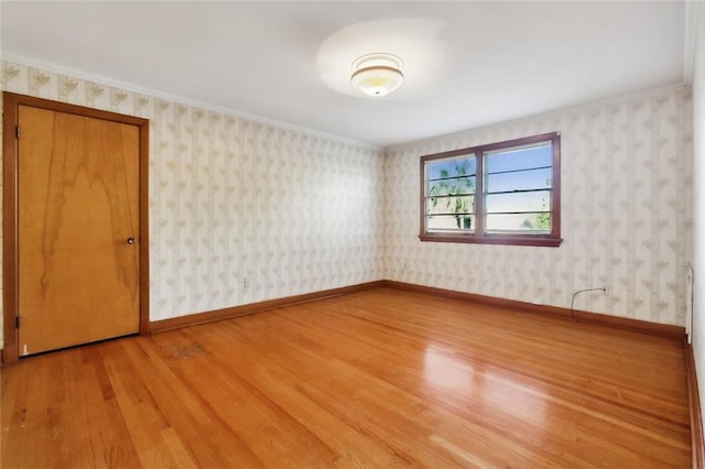 unfurnished room featuring wood-type flooring and ornamental molding