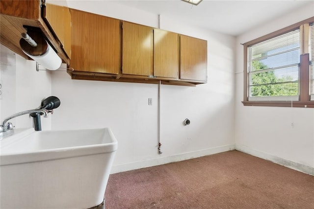 clothes washing area featuring carpet flooring, cabinets, and sink