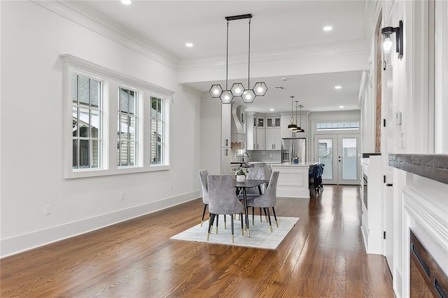 dining space featuring dark hardwood / wood-style flooring, ornamental molding, french doors, and sink