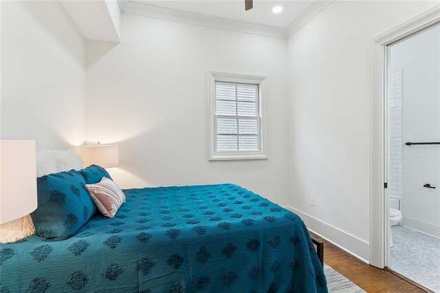 bedroom featuring ensuite bathroom, crown molding, and hardwood / wood-style floors