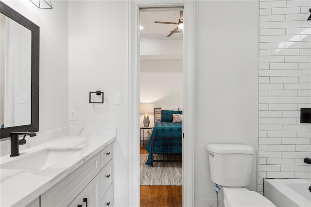 bathroom featuring hardwood / wood-style flooring, toilet, vanity, and ceiling fan