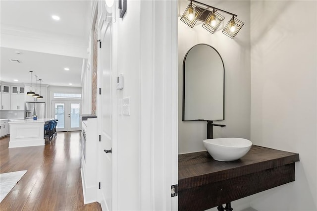 bathroom featuring decorative backsplash, hardwood / wood-style flooring, and vanity