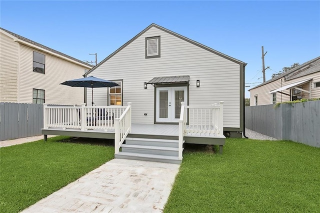 rear view of property featuring a wooden deck and a yard