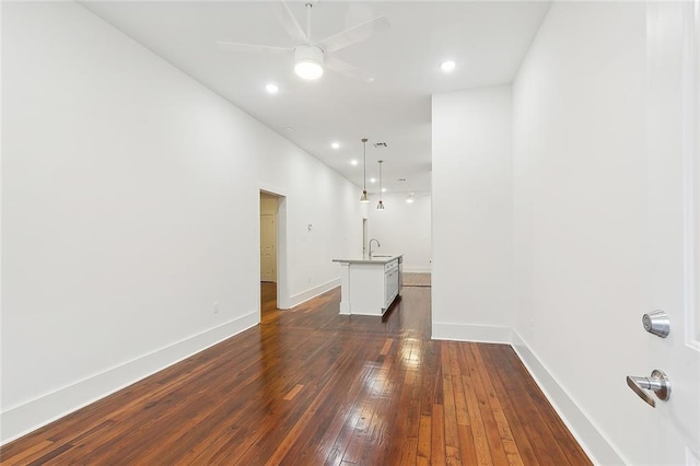 empty room featuring ceiling fan, sink, and dark wood-type flooring