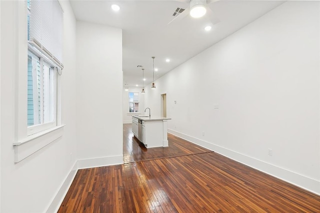 unfurnished living room with ceiling fan, dark hardwood / wood-style flooring, and sink