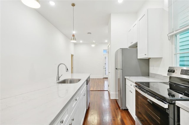 kitchen with pendant lighting, dark wood-type flooring, white cabinets, sink, and appliances with stainless steel finishes