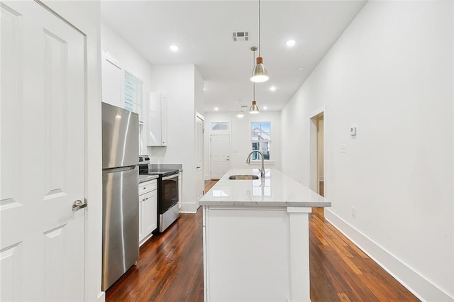 kitchen with sink, pendant lighting, a center island with sink, white cabinets, and appliances with stainless steel finishes