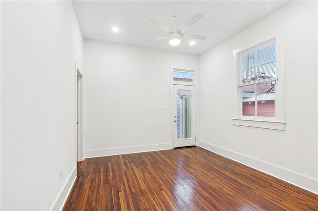 empty room with ceiling fan and dark wood-type flooring