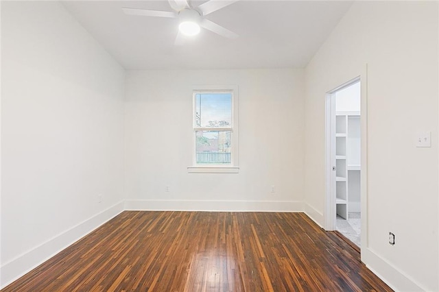 empty room with ceiling fan and dark hardwood / wood-style flooring