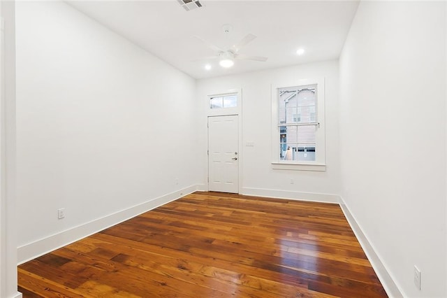 empty room with ceiling fan and dark hardwood / wood-style flooring