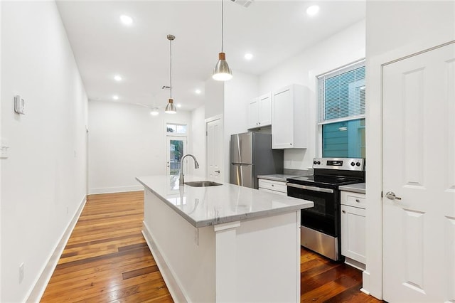 kitchen featuring pendant lighting, a kitchen island with sink, sink, white cabinetry, and stainless steel appliances