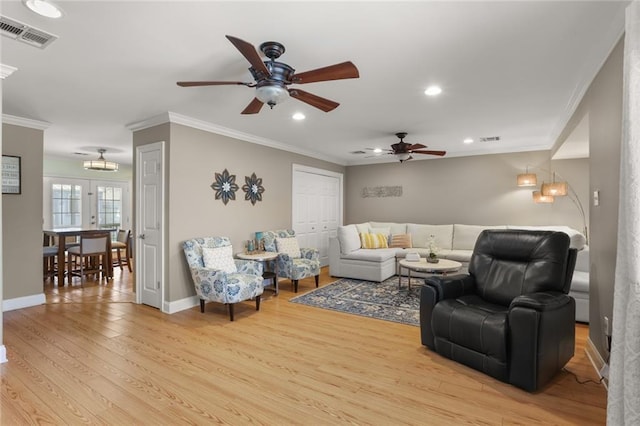 living room featuring crown molding, ceiling fan, and light wood-type flooring