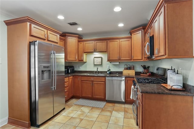 kitchen featuring dark stone countertops, crown molding, sink, and stainless steel appliances