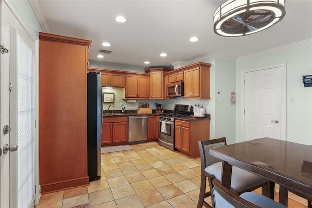 kitchen with sink, ornamental molding, stainless steel appliances, and light tile patterned floors