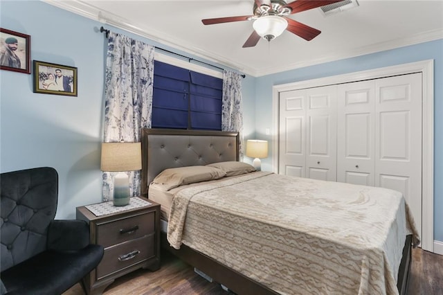 bedroom featuring ceiling fan, crown molding, dark wood-type flooring, and a closet