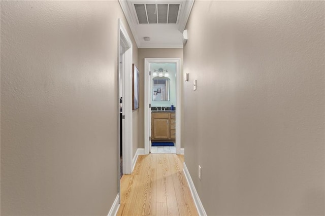 hall featuring light hardwood / wood-style floors and crown molding