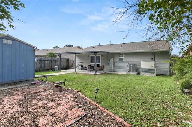 back of house with a lawn, ceiling fan, a shed, central AC unit, and a patio