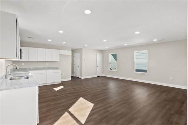 kitchen featuring light stone countertops, sink, white cabinets, and dark hardwood / wood-style floors