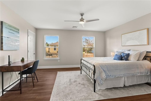 bedroom with dark hardwood / wood-style floors, ceiling fan, and multiple windows