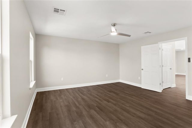 empty room with ceiling fan and dark hardwood / wood-style flooring