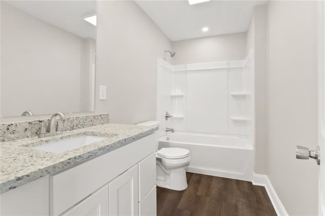 full bathroom with toilet, hardwood / wood-style floors, vanity, and washtub / shower combination