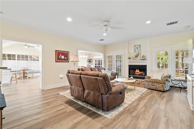 living room with french doors, light hardwood / wood-style flooring, ceiling fan, and ornamental molding