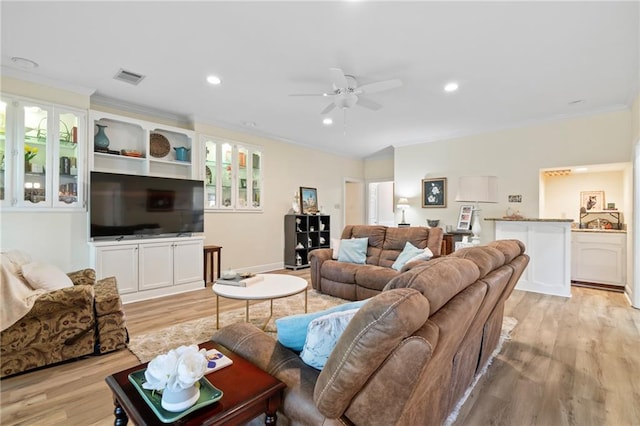 living room featuring ceiling fan, crown molding, and light hardwood / wood-style flooring