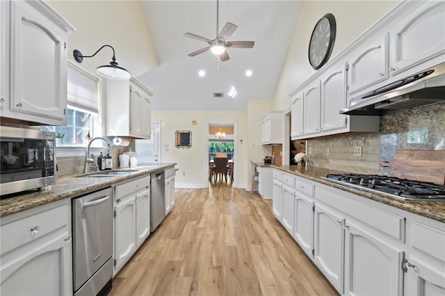 kitchen with sink, decorative backsplash, light hardwood / wood-style floors, white cabinetry, and stainless steel appliances