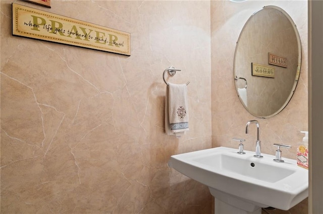 bathroom with sink and tile walls