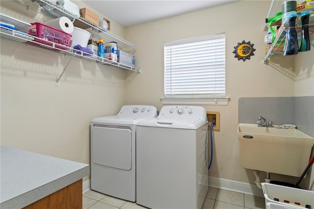 laundry room with light tile patterned flooring, sink, and washing machine and clothes dryer