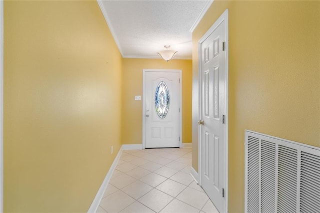 entryway with a textured ceiling, light tile patterned floors, and crown molding