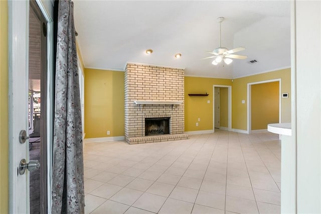 unfurnished living room featuring ceiling fan, light tile patterned flooring, crown molding, and a brick fireplace