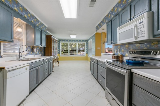 kitchen featuring decorative backsplash, sink, light tile patterned floors, and white appliances