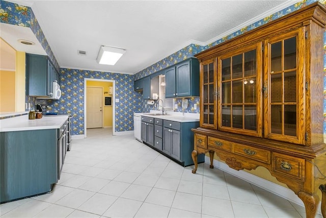 kitchen with stainless steel range with electric cooktop, crown molding, blue cabinets, and sink