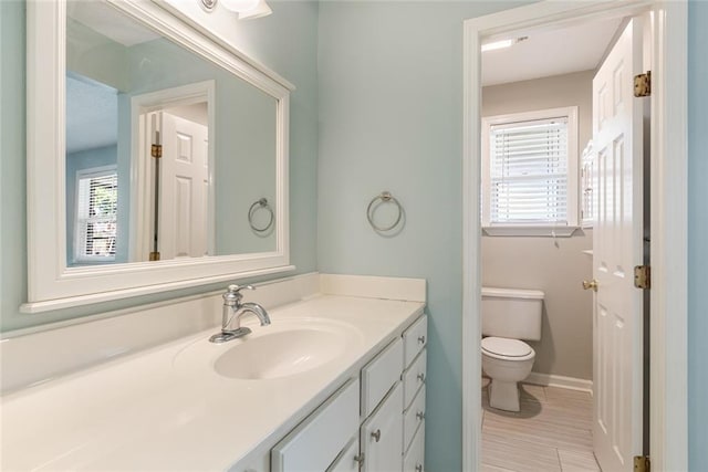 bathroom featuring vanity, toilet, and a wealth of natural light