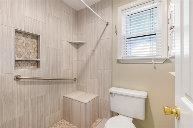 bathroom featuring toilet and tiled shower