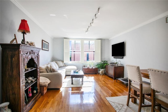 living room with crown molding, light hardwood / wood-style flooring, and rail lighting