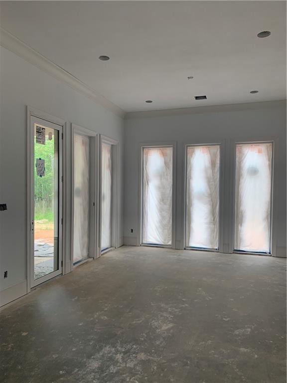 empty room with ornamental molding and concrete flooring