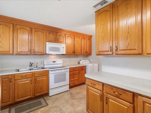 kitchen featuring washer / dryer, white appliances, and sink