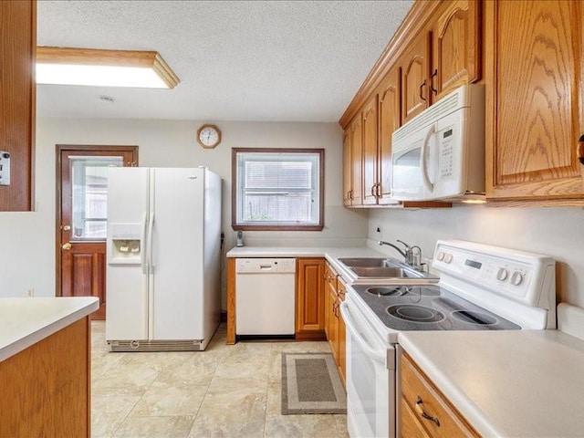 kitchen featuring a textured ceiling, sink, and white appliances