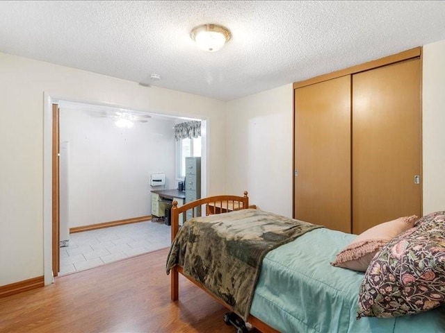 bedroom featuring a closet, wood-type flooring, and a textured ceiling