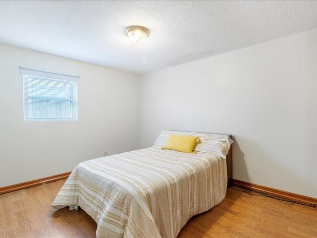 bedroom featuring hardwood / wood-style floors and a textured ceiling