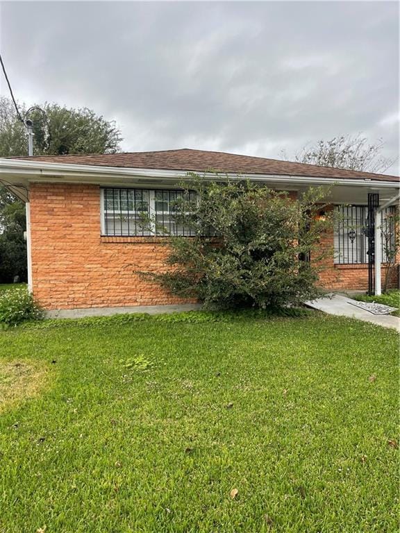 single story home featuring a front lawn