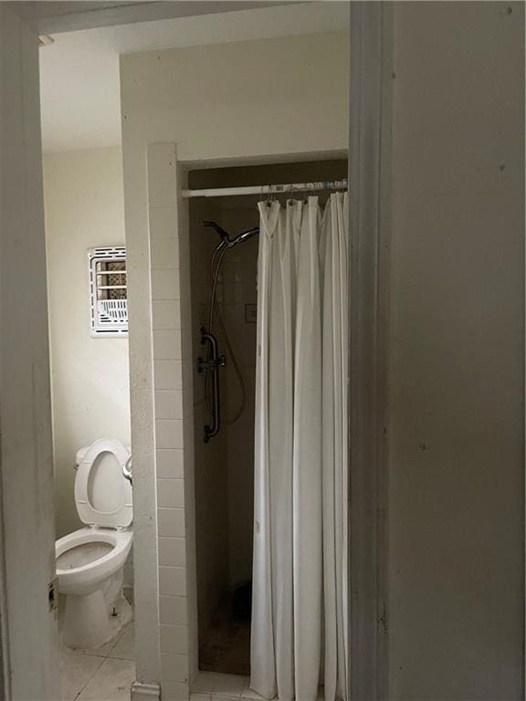 bathroom with toilet and a shower with shower curtain